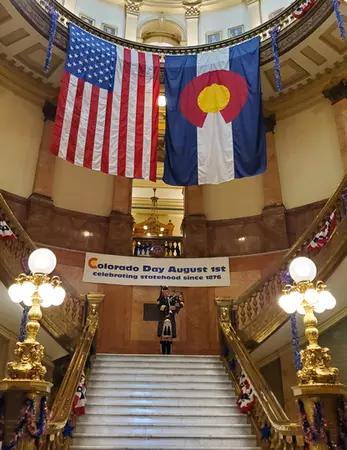 Colorado State Bagpiper on steps inside the State Capitol Atrium